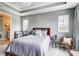 Bright main bedroom showcasing tray ceiling, natural light, and a comfortable queen-sized bed at 118 Isleworth Ave, Mooresville, NC 28117