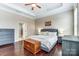 Bedroom features neutral walls, tray ceiling, and hardwood floors, with bathroom access at 120 Sycamore Dr, Lancaster, SC 29720