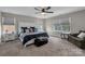 Cozy bedroom with plush carpeting, ceiling fan, a well-dressed bed and three large windows at 122 Round Rock Rd, Troutman, NC 28166