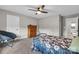 Bright bedroom features a ceiling fan, plush carpet and a floral comforter, with plenty of natural light at 122 Round Rock Rd, Troutman, NC 28166