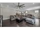 Open concept living room features a large sectional sofa, black ottoman, and flows into the dining and kitchen areas at 122 Round Rock Rd, Troutman, NC 28166