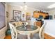 Dining area adjacent to kitchen features a chandelier, glass table, and wooden cabinets at 1249 Maddy Ln, Rock Hill, SC 29732