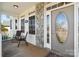 Close-up of the front porch featuring stone details, a decorative door, and comfortable seating at 1249 Maddy Ln, Rock Hill, SC 29732