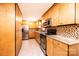 Modern kitchen with stainless steel appliances, wood cabinets, and mosaic tile backsplash at 1285 Riverview Dr, Hickory, NC 28602