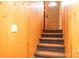 Stairway featuring wood paneled walls and carpeted steps leading to an upper level at 1285 Riverview Dr, Hickory, NC 28602