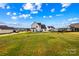 Expansive lawn behind a well-maintained home under a sunny sky with scattered clouds at 135 Goldenrod Cir, Salisbury, NC 28147