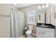 Well-lit bathroom with shower, toilet, single sink vanity and black granite countertop at 135 Goldenrod Cir, Salisbury, NC 28147