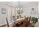 Formal dining room with chandelier lighting, a wooden table, and sliding glass doors to the backyard at 135 Goldenrod Cir, Salisbury, NC 28147