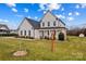 Two-story white farmhouse style home, with a front porch and well-manicured lawn at 135 Goldenrod Cir, Salisbury, NC 28147