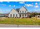 Charming two-story modern farmhouse with black roof, white siding, inviting front porch and manicured lawn at 135 Goldenrod Cir, Salisbury, NC 28147