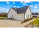 This home features an attached two-car garage, black roof, white siding and long concrete driveway at 135 Goldenrod Cir, Salisbury, NC 28147