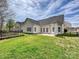 Backyard view of the house, manicured lawn, and patio, with an adjacent garden at 1394 Fitzgerald Nw St, Concord, NC 28027