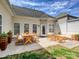 Backyard patio with outdoor seating, dining table, and string lights above, set against a partly cloudy sky at 1394 Fitzgerald Nw St, Concord, NC 28027
