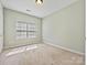 Minimalist bedroom with carpet, a window with blinds, and neutral wall color at 1394 Fitzgerald Nw St, Concord, NC 28027
