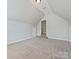 Upstairs bonus room with neutral carpet, ceiling light, and doorway with a small step at 1394 Fitzgerald Nw St, Concord, NC 28027