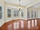 Bright dining area featuring a modern chandelier, hardwood floors, and multiple windows for natural light at 1394 Fitzgerald Nw St, Concord, NC 28027