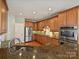 Gourmet kitchen with granite countertops, stainless steel appliances, custom cabinetry, and hardwood floors at 1394 Fitzgerald Nw St, Concord, NC 28027