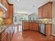 Open kitchen boasts stainless steel appliances, rich wood cabinets, hardwood flooring and granite countertops at 1394 Fitzgerald Nw St, Concord, NC 28027