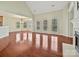 Spacious living room featuring hardwood floors, fireplace, large windows, and open layout to the kitchen at 1394 Fitzgerald Nw St, Concord, NC 28027