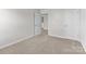 A bedroom shows neutral carpet, a door, and an open doorway leading to another room at 140 S Bell Ave, Albemarle, NC 28001