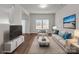 A beautifully staged living room area with hardwood floors, a large window, and neutral wall colors at 140 S Bell Ave, Albemarle, NC 28001