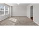 Spacious bedroom with neutral walls and carpeting is brightly lit by large windows at 142 S Bell Ave, Albemarle, NC 28001