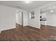 Open-concept living room with hardwood floors, white walls, and an opening to the kitchen at 142 S Bell Ave, Albemarle, NC 28001