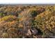 Stunning aerial view of a charming home nestled among vibrant fall foliage in a serene, wooded setting at 14725 N Old Statesville Rd, Huntersville, NC 28078