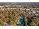 Aerial shot featuring vibrant tennis courts within a beautiful, tree-lined neighborhood setting and skyline at 14725 N Old Statesville Rd, Huntersville, NC 28078