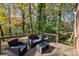 Outdoor seating arrangement on a wooden back deck surrounded by lush trees and foliage at 14725 N Old Statesville Rd, Huntersville, NC 28078