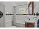 Classic bathroom with black-and-white tile, tub and shower combo, and pedestal sink at 14725 N Old Statesville Rd, Huntersville, NC 28078