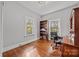 Bedroom with wood floors, two windows, bookcase, and classic desk at 14725 N Old Statesville Rd, Huntersville, NC 28078