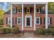 Close up of charming brick home with black shutters and a columned portico at 14725 N Old Statesville Rd, Huntersville, NC 28078