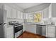 Bright kitchen with stainless steel appliances, white cabinets, and wood floors at 14725 N Old Statesville Rd, Huntersville, NC 28078