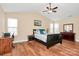 A bright bedroom features a ceiling fan, hardwood floors and natural light at 15707 Southern Garden Ln, Charlotte, NC 28278