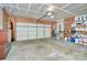 Spacious garage with storage shelving, tools, and a roll-up garage door at 15707 Southern Garden Ln, Charlotte, NC 28278