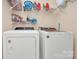 Laundry area featuring a washer, dryer, and storage shelving at 15707 Southern Garden Ln, Charlotte, NC 28278
