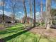 Spacious backyard with lush green grass, mature trees and partial fence for plenty of room to play at 15715 Holyhead Ln, Huntersville, NC 28078