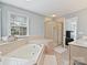 Bright bathroom showcasing shower, soaking tub, and window allowing natural light at 15715 Holyhead Ln, Huntersville, NC 28078