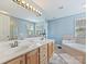 Spacious bathroom with double sinks, large mirror, soaking tub, and natural light at 15715 Holyhead Ln, Huntersville, NC 28078