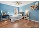 Inviting bedroom showcasing hardwood floors, ample natural light, and comfortable furnishings at 15715 Holyhead Ln, Huntersville, NC 28078