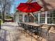 Spacious wooden deck with large table and a red umbrella surrounded by a well-maintained backyard at 15715 Holyhead Ln, Huntersville, NC 28078