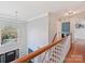 Elegant staircase with wood railing and a grand chandelier, creating a warm and inviting entryway at 15715 Holyhead Ln, Huntersville, NC 28078
