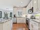 Bright kitchen features white cabinets, stainless steel appliances, and wood floors with adjacent dining area at 15715 Holyhead Ln, Huntersville, NC 28078