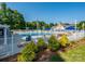 Upscale community pool area with lounge chairs, blue umbrellas, and lush landscaping within a gated fence at 15715 Holyhead Ln, Huntersville, NC 28078