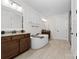 Well-appointed bathroom featuring double vanity sinks, a soaking tub, and neutral-toned tile floors at 158 Country Lake Dr, Mooresville, NC 28115