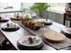 Dining table decor features wood chargers, floral arrangements, neutral runner, and white plates at 158 Country Lake Dr, Mooresville, NC 28115