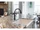 Close up of kitchen with granite countertops, white sink, faucet, and open view to the breakfast nook at 158 Country Lake Dr, Mooresville, NC 28115