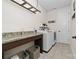 Functional laundry room with granite countertop, shelving, tile floor, and front-load washer and dryer at 158 Country Lake Dr, Mooresville, NC 28115