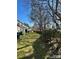 A spacious backyard featuring a well-maintained lawn, mature trees, and a natural privacy hedge for outdoor enjoyment at 1754 Pergola Pl, Charlotte, NC 28213